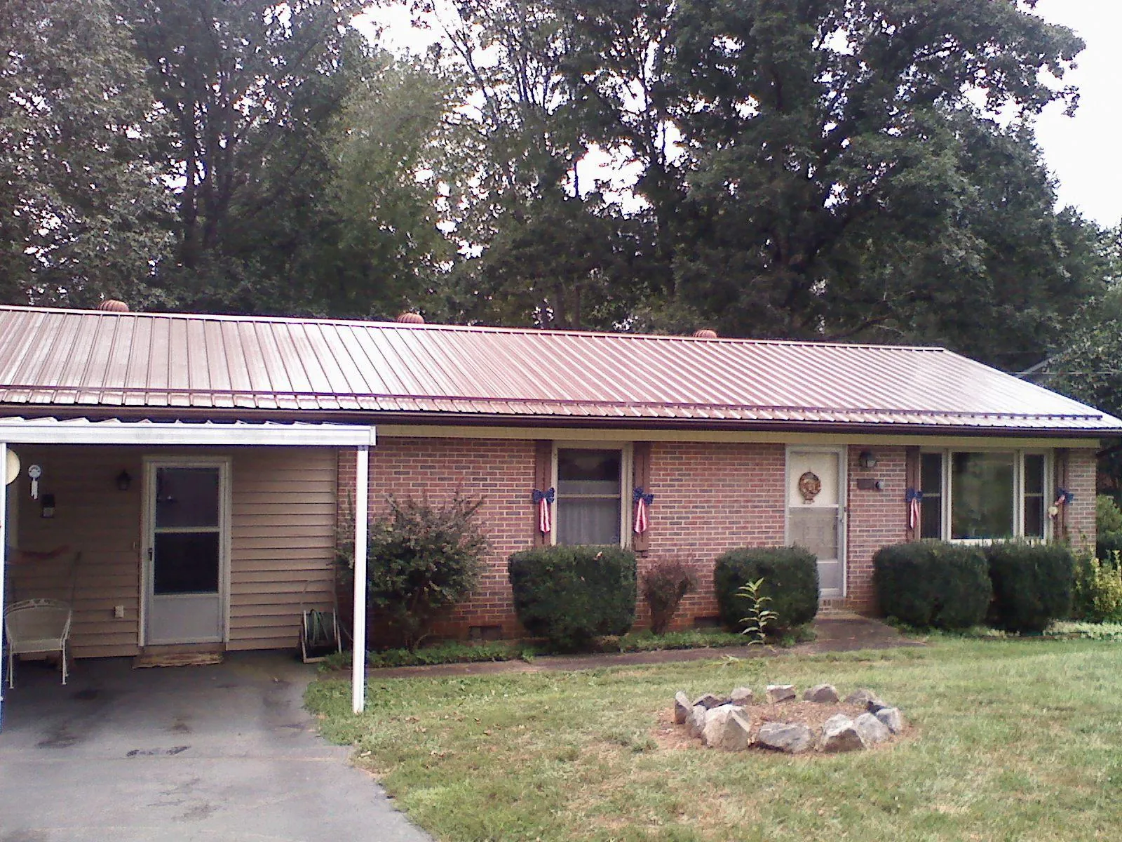 Bronze metal roof and carport on a brick ranch home — Roof Repair work by our crew in Cairnbrook